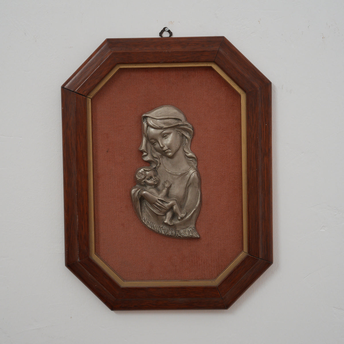 Madonna con Bambino in Braccio – Bassorilievo in Metallo Argentato su Tessuto Rosa Antico, Cornice Ottagonale in Legno, 42 x 32 cm