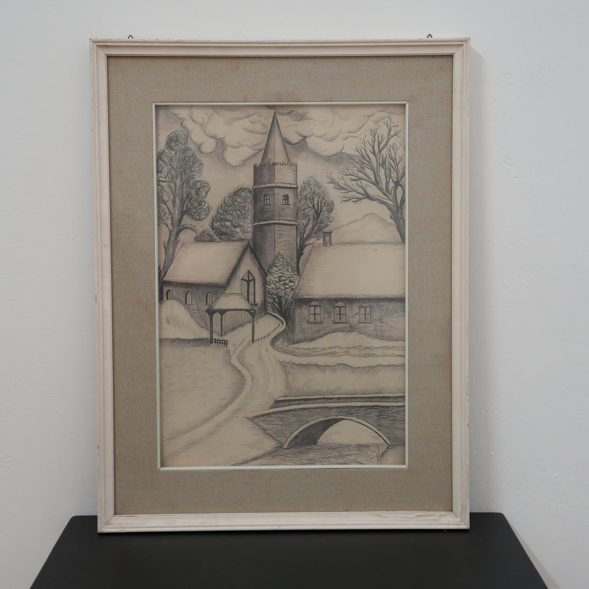 Disegno a penna "Chiesa nel villaggio innevato" – paesaggio invernale con ponte, firmato, cornice bianca – 63 x 49 cm